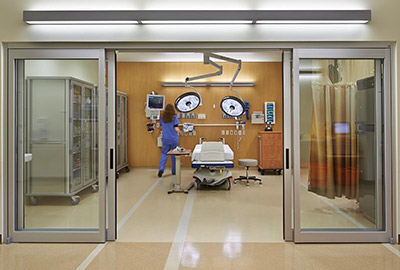 Wide sliding glass doors at the entrance to a hospital treatment room